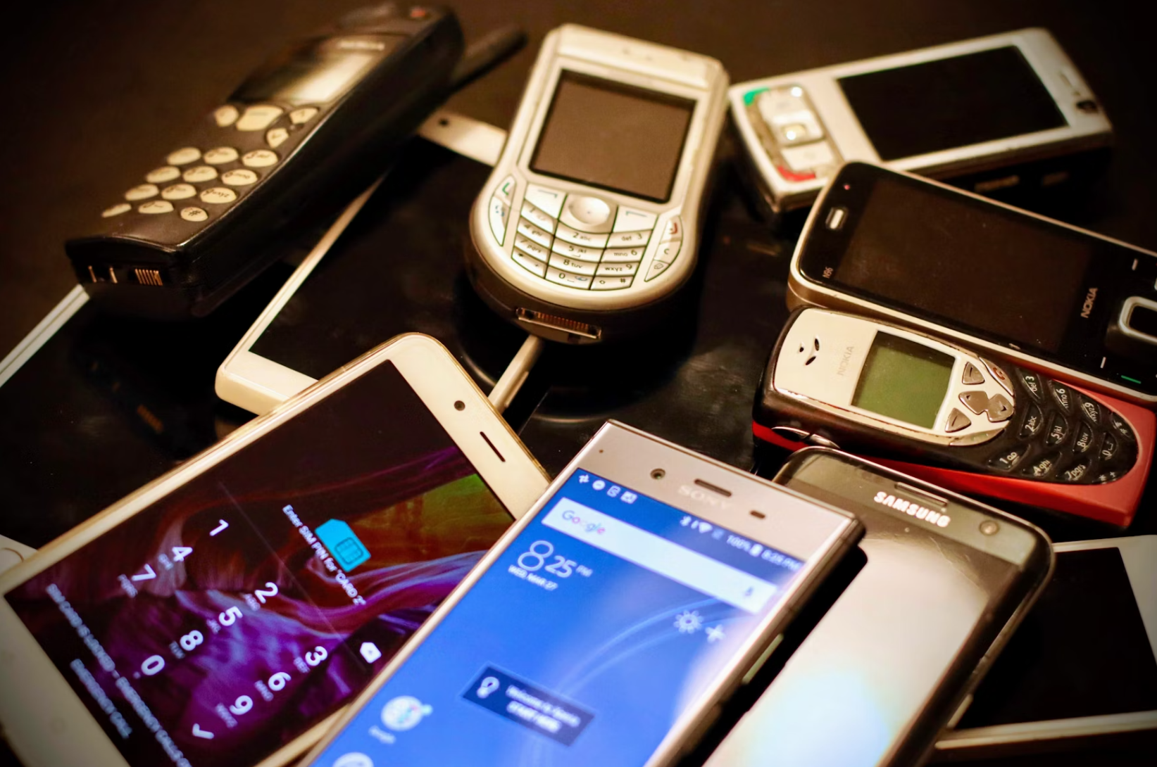 A collection of old mobile phones from various decades