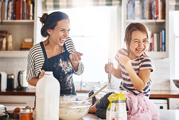 A person and child making a cake

Description automatically generated